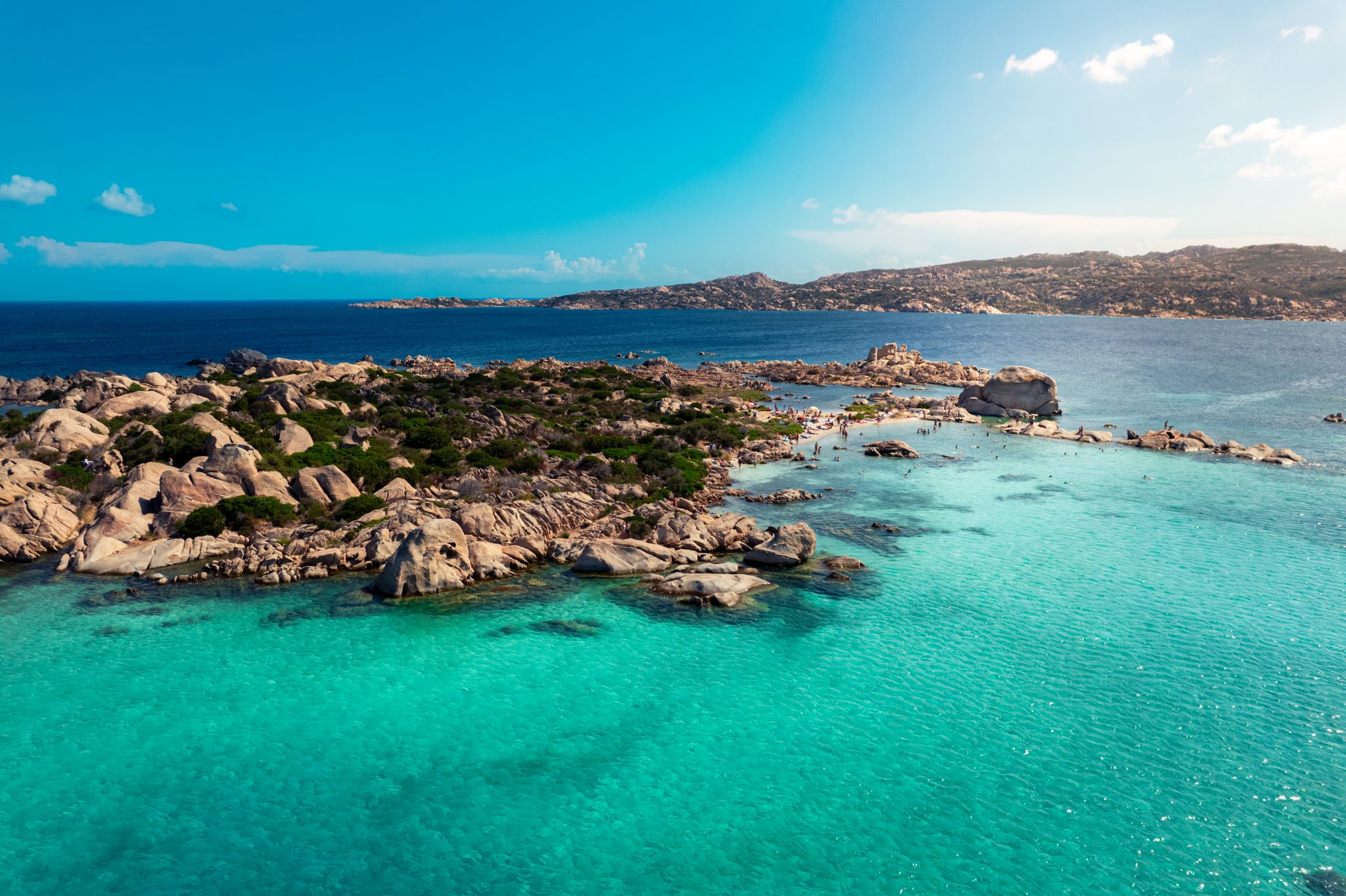 Vista aèria d'una platja amb roques i aigües cristal·lines feta per PinStudio amb dron. Productora audiovisual a Barcelona.